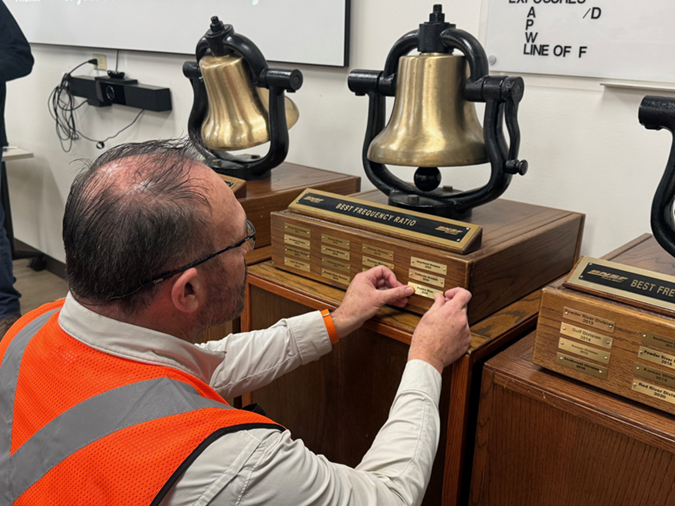 Engineer and Safety Leader Steve Mullen applies the Powder River Division 2025 plaque on the Safety Bell. 